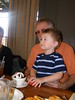 Gage-MaxsNanny > Gage is carefully watching the waitresses singing "Happy Birthday" to PaPaw.  He told him that they were "too loud" when they were done. Ha!